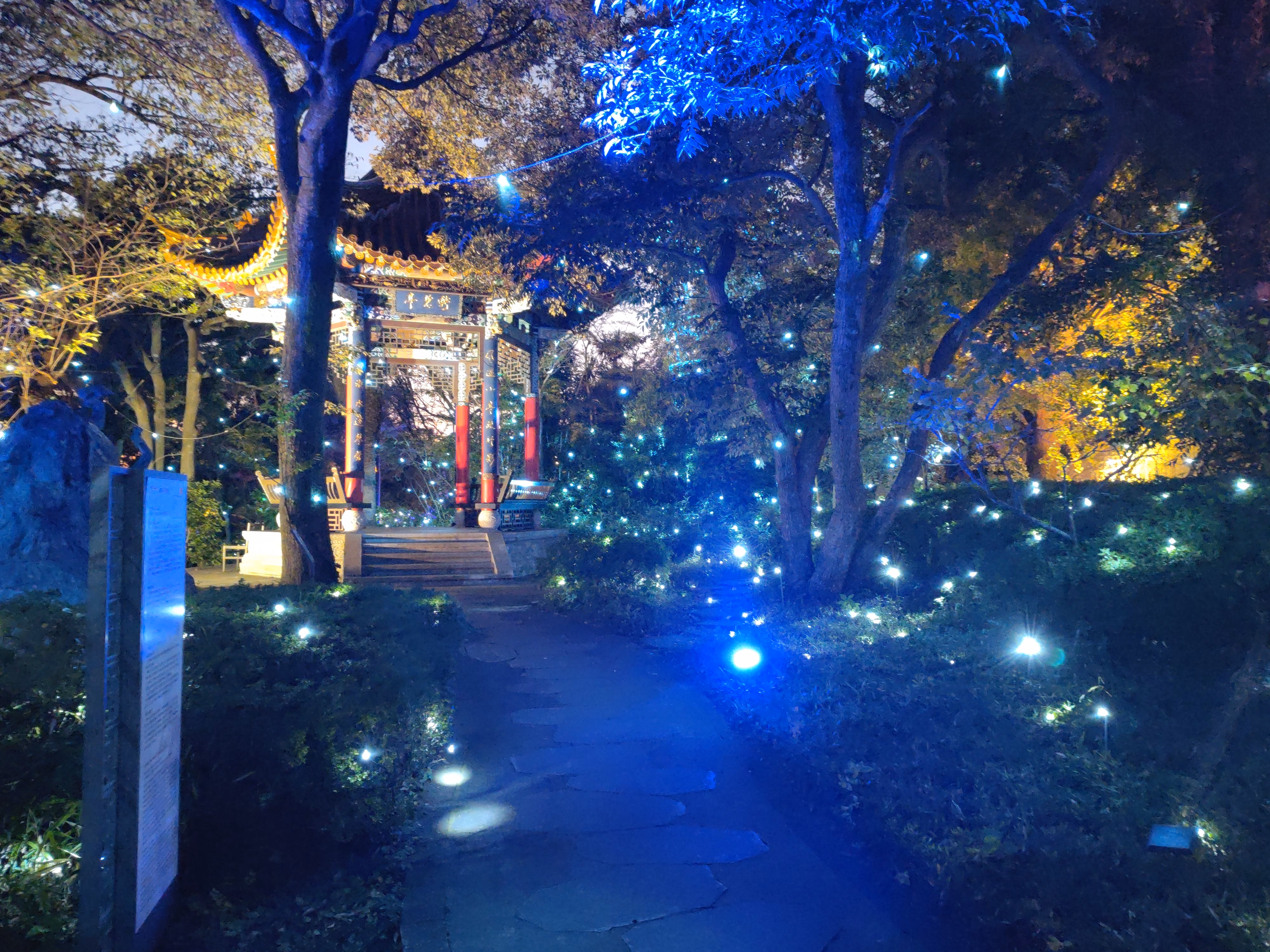 A small decorated shelter amidst lit trees.