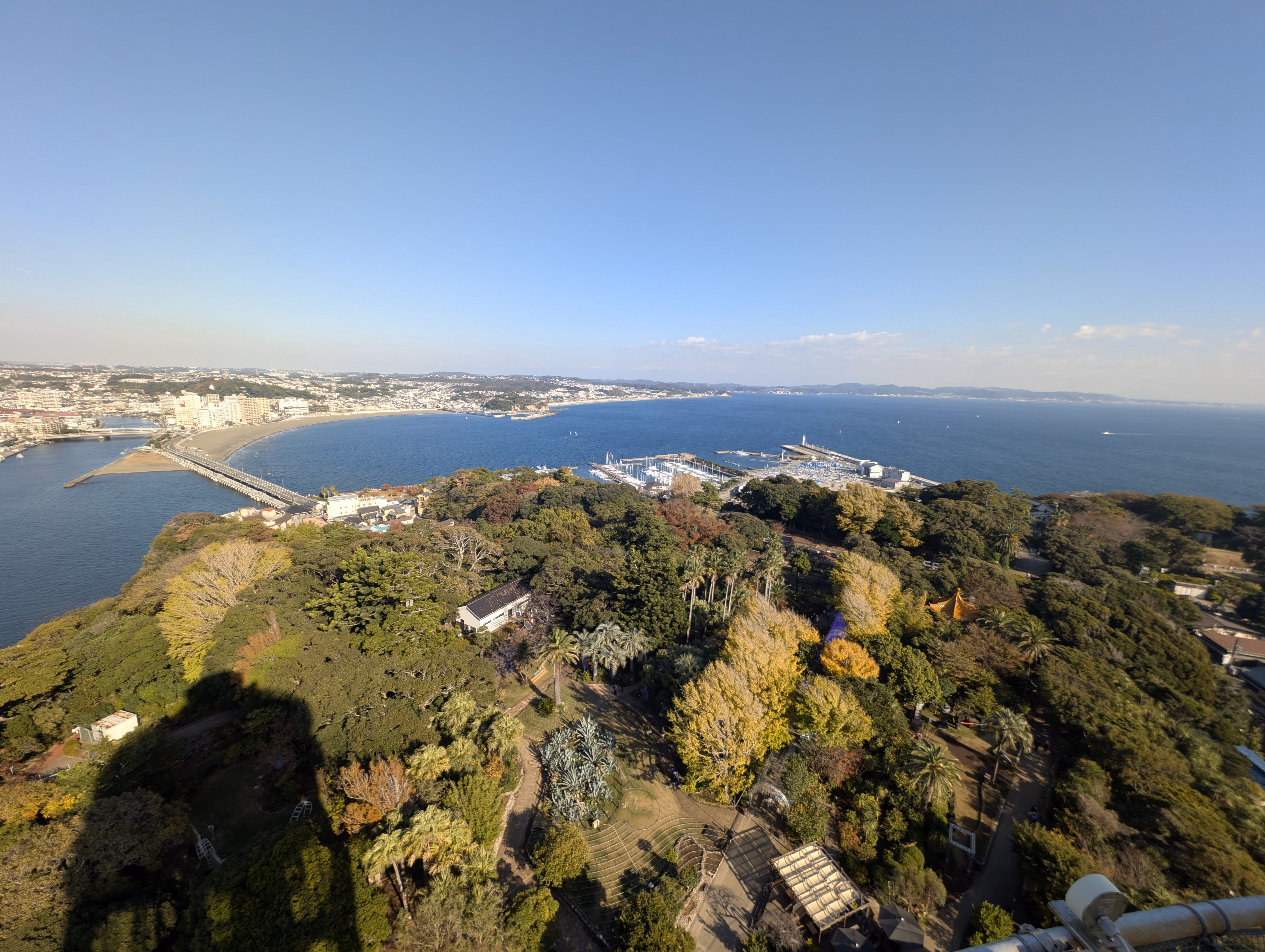 Eastward view again: A deep blue sea behind Enishima, with its harbour visible in the center left of the image.
