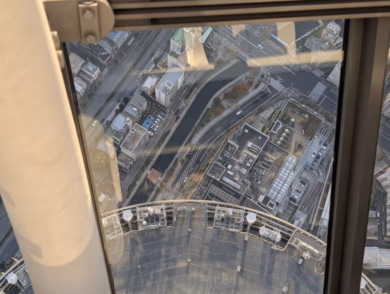 Downwards view from the top deck of the sky-tree through a downwards angled window. It is clearly very high up.