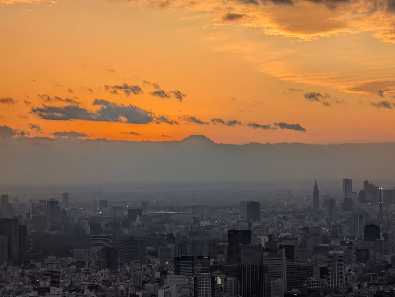 A more zoomed in picture with the top of Fuji being very visible against the golden backdrop of the sunset.