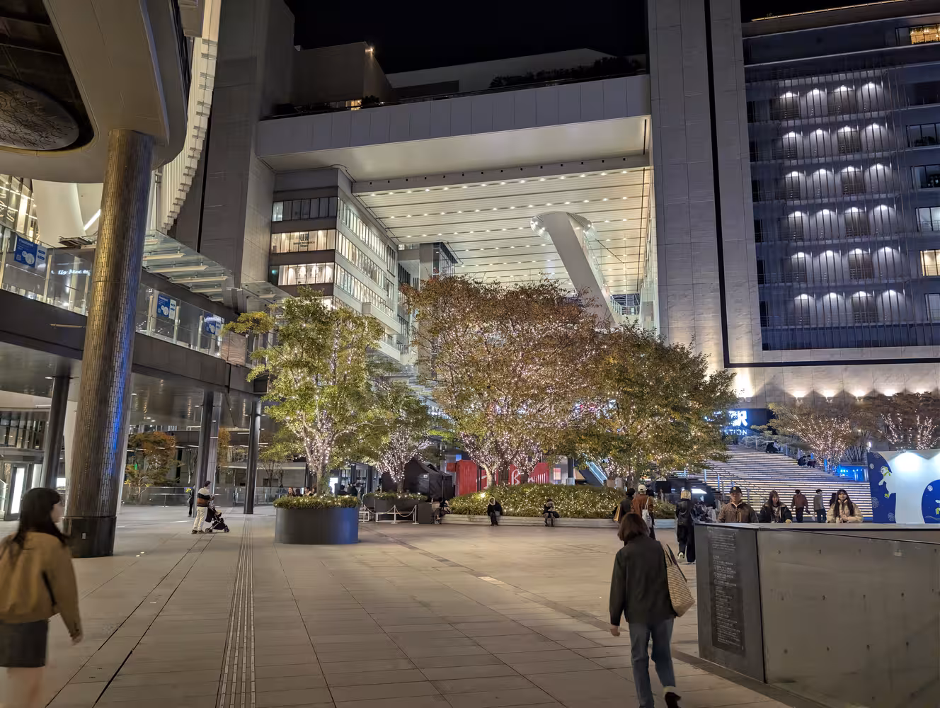 The entrance of Osaka station, with large, lit trees in front of it.