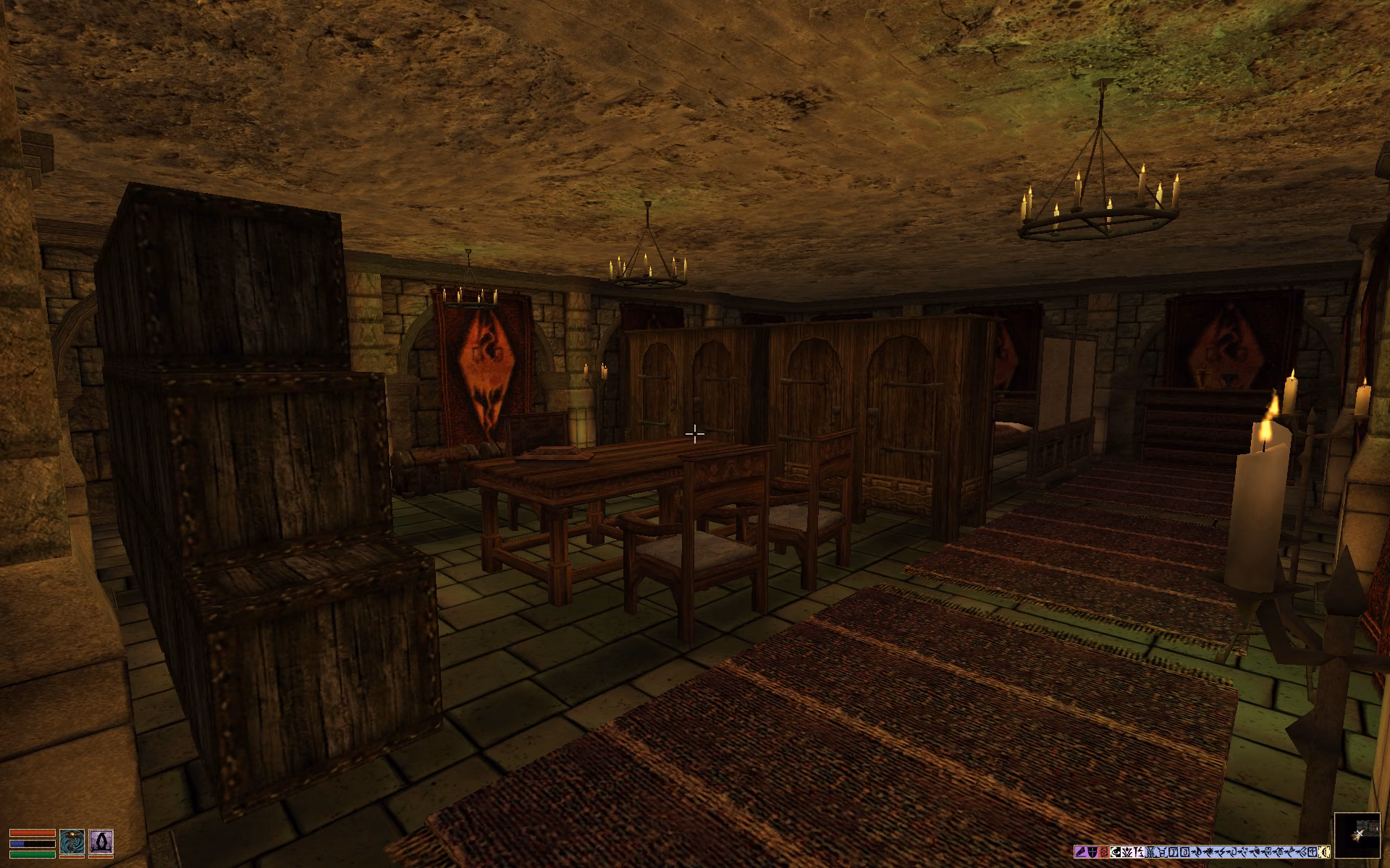 View into the chamber: There are some carpets on the stone-tiled floor, several creates, cabinets, and chests, as well as a table with two chairs in front and one behind it. Lighting is done via several chandeliers.